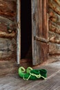 Fairy creature elf or forest dwarf left his shoes on the threshold of an old wooden house near the front door Royalty Free Stock Photo