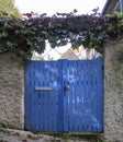 Fairy Garden With a Gate. Blue Gate with a Natural Hedge of Greenery to a Cozy House or Garden