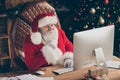 Fairy jolly holly santa claus sit table work computer look screen read wish list letter gift present email touch hand
