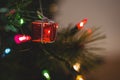 Fairy light and small gift box hanging on christmas tree Royalty Free Stock Photo