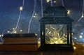 fairy lights inside old lantern and antique books