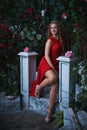 Fairy tale. Beautiful princess in red dress sitting in a mystical garden Royalty Free Stock Photo