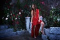 Fairy tale. Beautiful princess in red dress sitting in a mystical garden Royalty Free Stock Photo