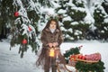 Fairy tale girl. Portrait a little girl in a deer dress with a painted face in the winter forest. Big brown antler