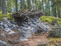 Fairy tale house for dwarf in forest build by children from stones, wood and moss, playing in forest, tree background