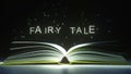 FAIRY TALE text made of glowing letters vaporizing from open book. 3D rendering