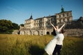 Fairy-tale wedding couple handsome groom swinging beautiful bride at sunset castle background Royalty Free Stock Photo