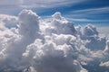 Fairy, white cumulonimbus clouds and blue sky. View from the airplane window