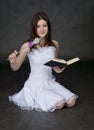 Fairy in a white dress with magic wand and book