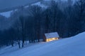 Fairy winter landscape with snowy cabin in the mountains