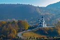 Fairytale landscape: country road leading to majestic church on a hill in the middle of nature, fall/autumn colors and blue skies Royalty Free Stock Photo