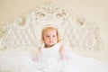 Fairytale princess. Small blond child sit on bed. Little girl wear tiara crown and hairstyle. Hair accessory. Little Royalty Free Stock Photo