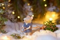 A fairytale rat in a fur coat carries a Christmas tree from a magical fairytale forest lit by lanterns. Royalty Free Stock Photo