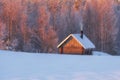 Fairytale small wooden house or sauna near the winter forest in the snow and smoke from the chimney. Winter Christmas landscape Royalty Free Stock Photo