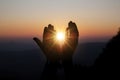 Spiritual prayer hands over sun shine with blurred beautiful sunset background Royalty Free Stock Photo