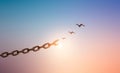 Silhouettes of broken chain and birds flying in sunrise sky background. Royalty Free Stock Photo