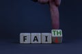 Faith instead fail symbol. Businessman turns a wooden cube and changes the word fail to faith. Beautiful grey table, grey Royalty Free Stock Photo