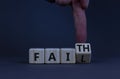 Faith instead fail symbol. Businessman turns a wooden cube and changes the word fail to faith. Beautiful grey table, grey Royalty Free Stock Photo