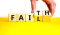 Faith instead fail symbol. Businessman turns wooden cubes and changes the concept word Fail to Faith. Beautiful yellow table white Royalty Free Stock Photo