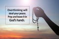 Faith inspirational quote - Overthinking will steal your peace. Pray and leave it in God`s hands. With hand holding Rosary. Royalty Free Stock Photo