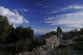 Old chapel in Mani, Greece, with olive trees and a deep-blue sky