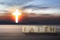 Faith text on wooden table with Christian cross