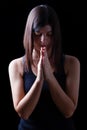 Faithful athletic woman praying, with hands folded in worship to god