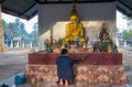 Faithful buddhist woman prays in the Akat Amnuai temple, Sakon Nakhon province, Isan, Thailand