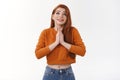 Faithful cute urban redhead girl implore God praying hold palms together plead supplicating look up sky optimistic