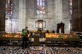 Faithful man lights a sacrificial candle at the altar of the Virgin Mary in Milan Cathedral, Lombardy, Italy