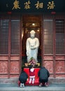 The faithful are praying in Longhua buddhist temple. White buddha statue in Longhua temple, Shanghai China Royalty Free Stock Photo