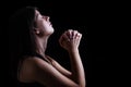 Faithful woman praying, hands folded in worship
