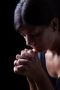 Faithful woman praying, hands folded in worship to god