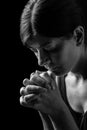 Faithful woman praying, hands folded in worship to god