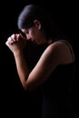 Faithful woman praying, hands folded in worship to god with head down and eyes closed Royalty Free Stock Photo