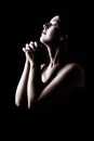 Faithful woman praying, hands folded in worship to god with head up and closed eyes Royalty Free Stock Photo