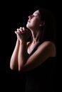 Faithful woman praying, hands folded in worship to god with head up and closed eyes Royalty Free Stock Photo