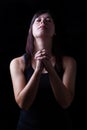 Faithful woman praying, hands folded in worship to god