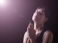 Faithful woman praying under a divine or celestial light