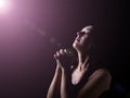 Faithful woman praying under a divine or celestial light