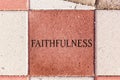 The Word Faithfulness on a sidewalk paver Royalty Free Stock Photo