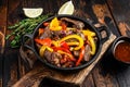 Fajitas beef meat traditional Mexican food dish in a pan. Dark wooden background. Top view