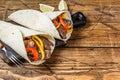 Fajitas Tortilla wrap with beef meat stripes, colored bell pepper and onions and salsa. Wooden background. Top view. Copy space
