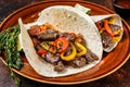 Fajitas Tortilla wraps with beef meat steak stripes, sweet pepper and onions. Dark Wooden background. Top view Royalty Free Stock Photo