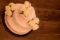 Fake cake with flowers on wooden background.