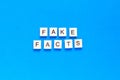 Fake facts word alphabet letters on blue background. top view. flat layout