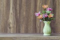 Fake flowers in a vase placed on a table on a wooden table with copy space for design wood grain vintage background Royalty Free Stock Photo