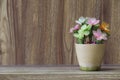 Fake flowers in a vase placed on a table on a wooden table with copy space for design wood grain vintage background Royalty Free Stock Photo