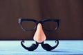 Fake mustache, nose and eyeglasses on a blue surface Royalty Free Stock Photo