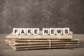 Fake News concept with newspapers and cubes with letters Royalty Free Stock Photo